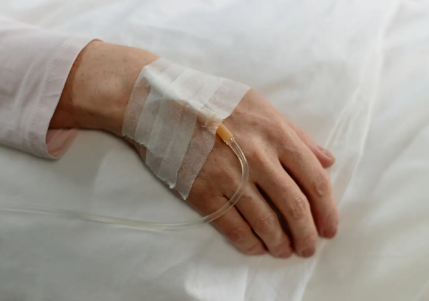 Kroplówki witaminowe Mielec: dłoń z podłączoną kroplówką w spokojnym kadrze