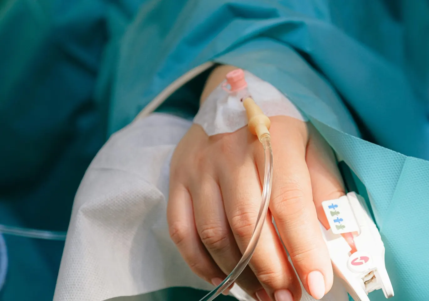 Detoks alkoholowy Łańcut: dłoń z wenflonem i pulsoksymetrem pod nadzorem